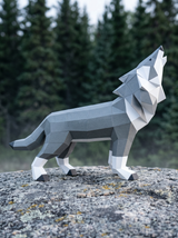 3D papercraft wolf model on a rock with a forest background